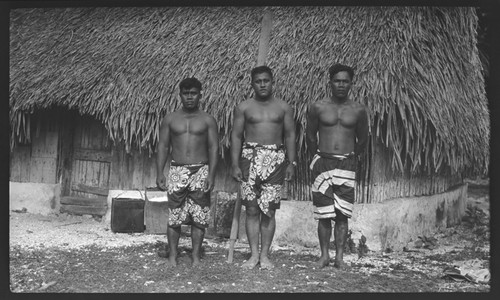 Three men in front of a house