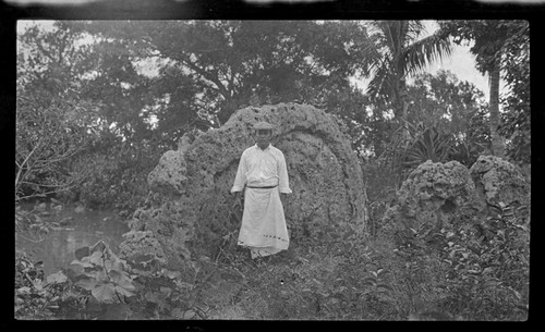 Portrait of man, standing in front of possible shrine