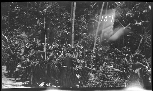 Several people dancing, wearing indigenous clothing