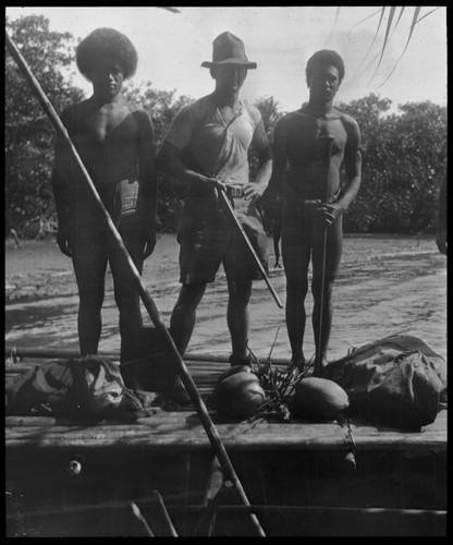 Portrait of men on boat, European man in middle holding gun