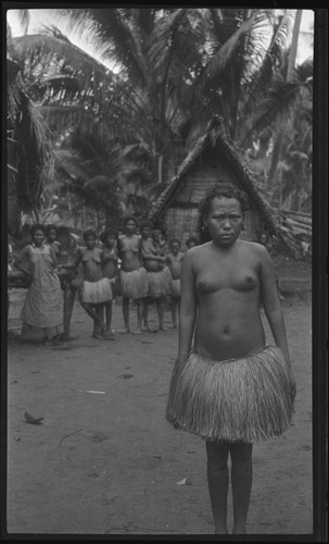 Woman in front of group and house