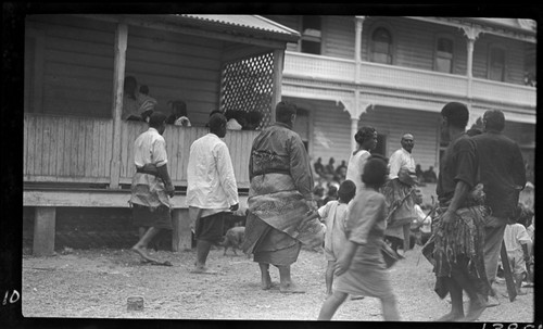 Men,women and children approaching buildings