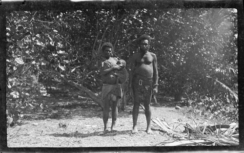 Man, and woman carrying infant in sling