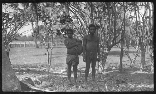 Man, and woman with child in carrying sling