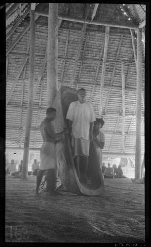 Huge food bowl in maneaba meeting house of Tabiteuea, said to belong to Kourabi; man standing in bowl is descendent of Kourabi and clan chief