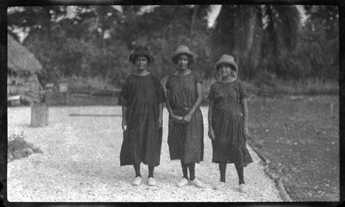 Women in hats, white shoes, and dark dresses