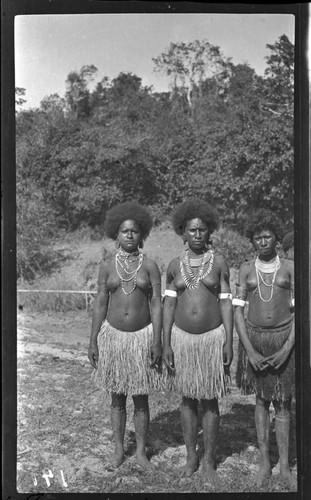 Women wearing several necklaces, including kina, a crescent shell valuable