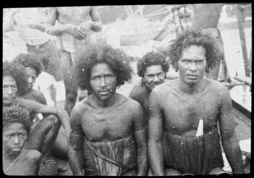 Group of men, and a boy; man on right has large earrings