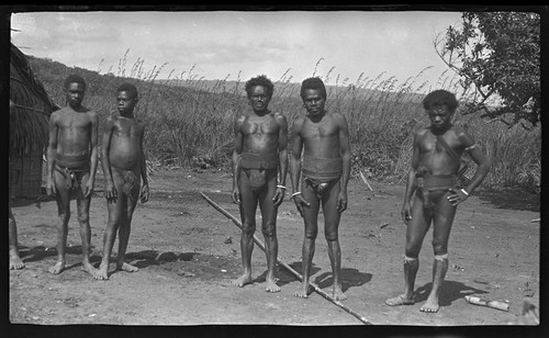 Men, and a boy, near a house