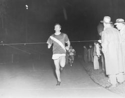 Analy High School Tigers track, 1960s--an unidentified Analy runner at a night time track meet nearing the finish line