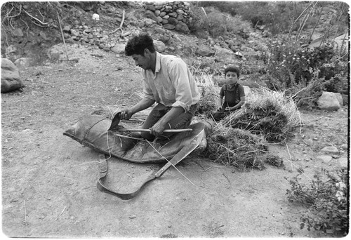 Francisco Arce stuffing ranch-made packsaddles with fresh straw at Rancho San Gregorio