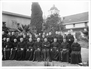 Group portrait of about 30 Franciscan monks outside at Mission Santa Barbara, 1904