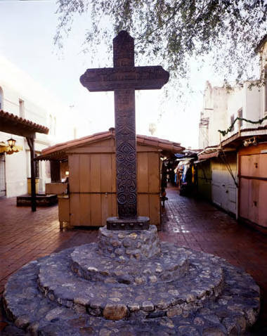 View of Olvera Street cross with booths in background