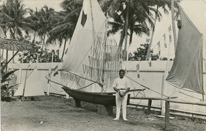 A leper, in front of the boat he is building