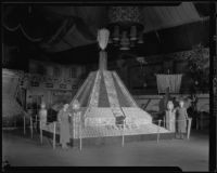 Two women stand beside the Ontario display at the National Orange Show, San Bernardino, 1935