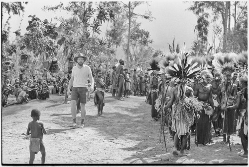 Pig festival, singsing, Kwiop: Edwin Cook walks past spectators and decorated dancers