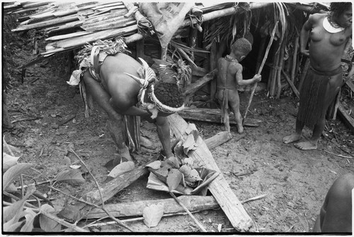 Bride price ritual: man wearing hornbill beak ornaments places wealth objects in leaf packet