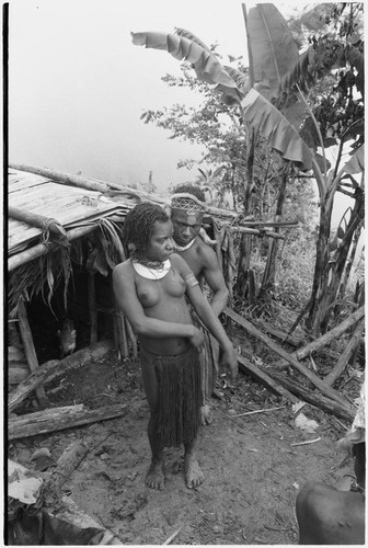 Bride price ritual: man helps woman adjust her skirt