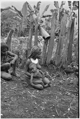 Woman holds string, another woman with infant