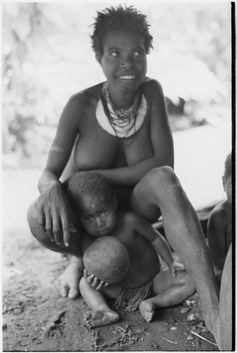 Bomagai: smiling woman, young child holds ball made from pig's bladder