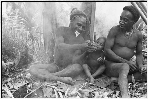 Man holds a frog for boy to touch