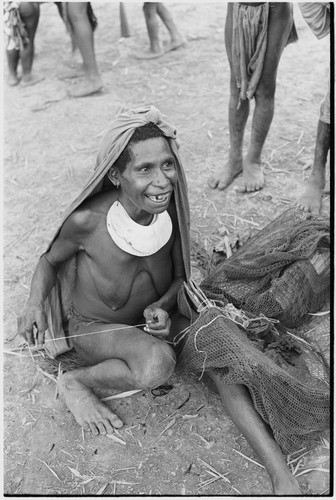 Pig festival, singsing, Kwiop: woman spins twine for weaving a netbag