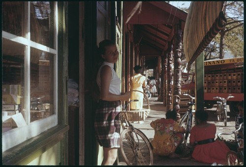 Ann Rappaport in Papeete, carved columns in front of store