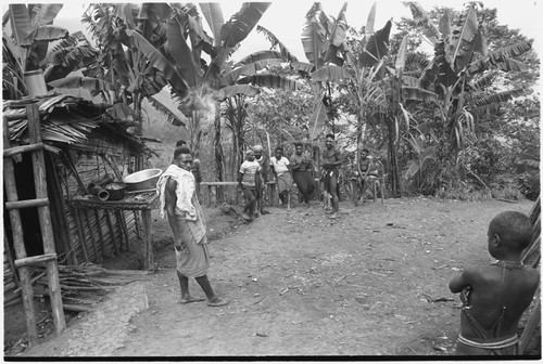 Men, some in western clothing, gathered at a house