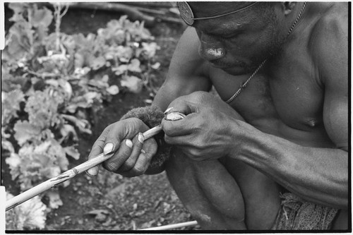 Carving: stone tool being used to smooth an arrow