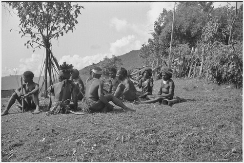 Men on grounds of government rest house in Tsembaga, their bows and arrows propped beside them