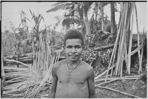 Young man, woven wall panel and other building materials in background