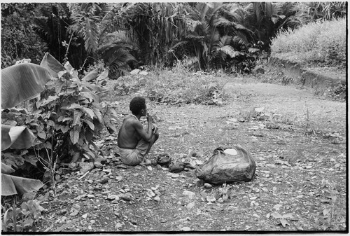 Schrader Range: Kalam man with netbag sits by trail