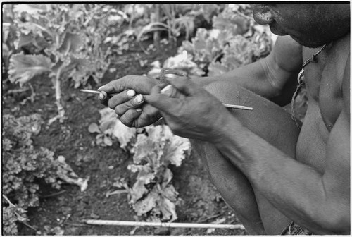 Carving: stone tool being used to smooth an arrow