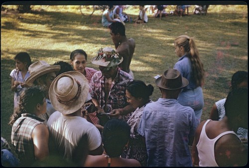 Local people, some with decorated hats, waiting to view archaeology exhibit, Moorea