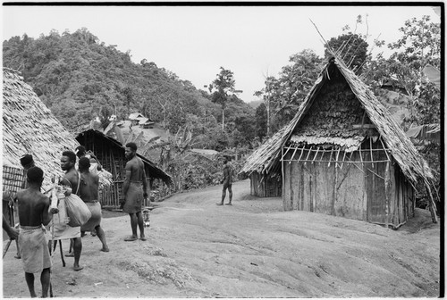 Atitau area, Wanuma Census Division: carriers pass through a village