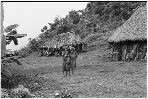 Fainjur: women and young girl stand near houses