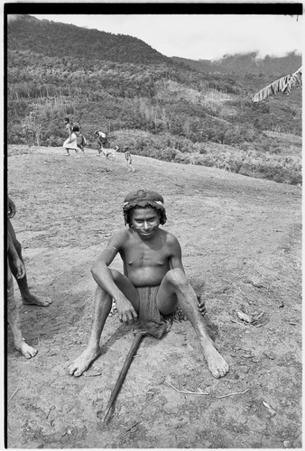 Adolescent boy with barkcloth cap and axe