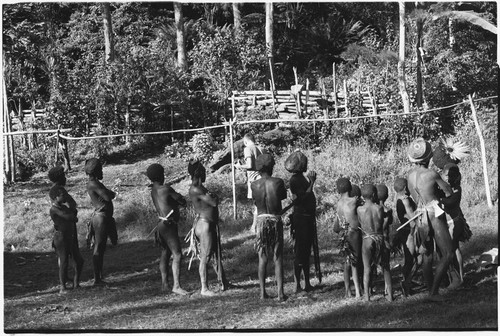 Pete Vayda brushes his teeth, watched by men and children