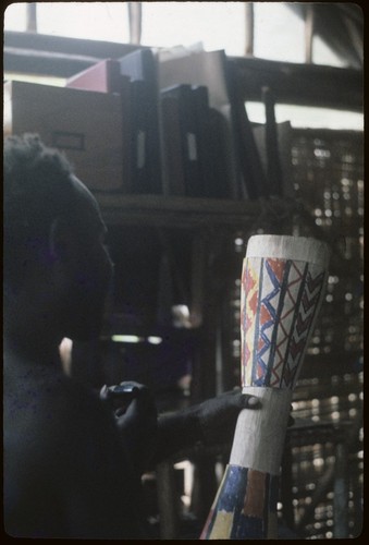 Abint paints designs on a drum, inside of Rappaport's house