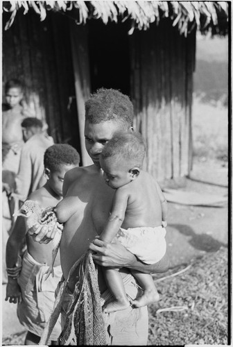 Wanuma: woman holds infant and young cassowary at Lutheran mission