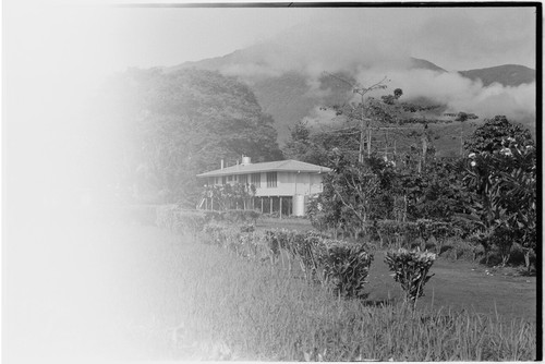 Aiome: government or mission building, water tank, Schrader Range in background