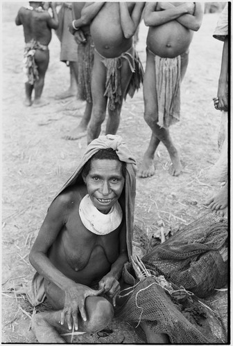 Pig festival, singsing, Kwiop: woman spins twine for weaving a netbag