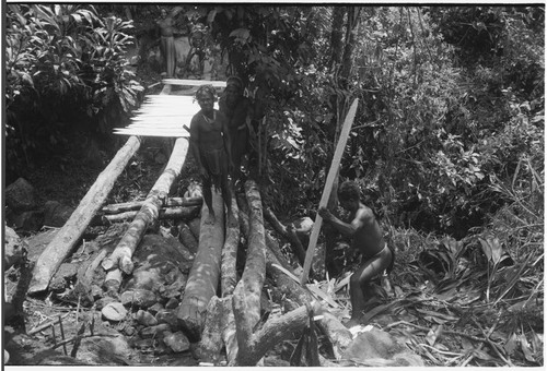 Bridge-building: men place planks for deck