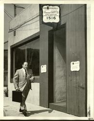 Alan Reed in suit walking down the street — Calisphere