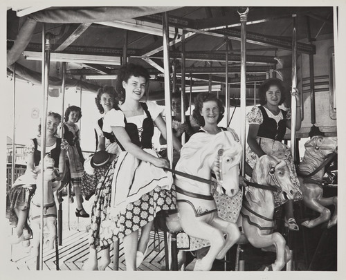 The 1949 Cherry Festival Queen and her Court riding a merry go round