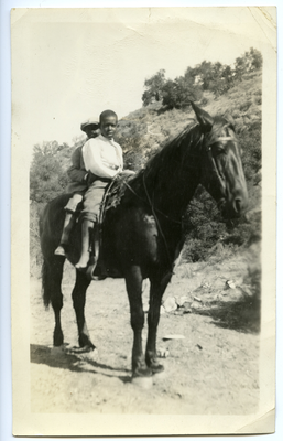 Two boys riding horse