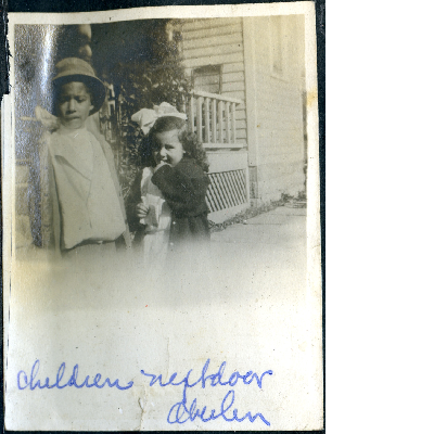 Boy and girl standing in front of house