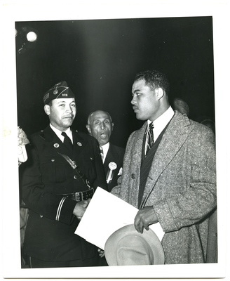 Joe Louis and unidentified man shaking hands, Frederick Roberts stands in the background