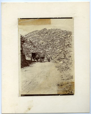 Five men walking next to horse-drawn carriage