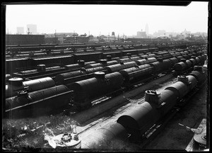 Railroad cars parked in a freight yard in Elysian Park, looking towards Los Angeles City Hall, January 20, 1931